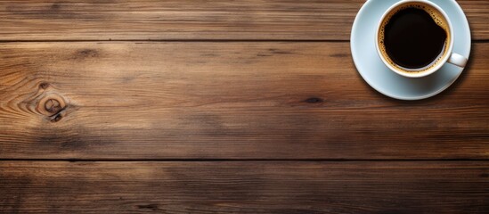 Canvas Print - Top view of a cup of coffee resting on a wooden table with ample space in the image for copying and pasting