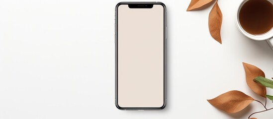 Poster - A phone mockup rests on a white table accompanied by a cup of coffee and leaves creating a visually appealing copy space image