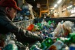 A man is sorting plastic bottles in a warehouse, disposing them into an overflowing recycling bin