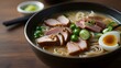 A steaming bowl of ramen adorned with slices of tender pork and vibrant green onions --