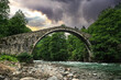 Ancient stone arch bridge and mountain river	