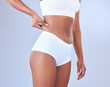 © peopleimages.com - Black woman, hands and weight loss with body fat in underwear for tummy tuck or lipsuction on a blue studio background. Closeup of African or female person touching skin, stomach or belly for diet