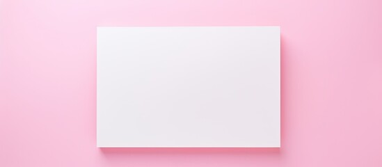 Fototapete - Top view of a trendy and minimal creative concept with a paper blank on a pastel pink background The colorful background enhances the aesthetic while the copy space provides room for additional eleme