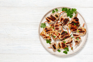 Wall Mural - grilled mini pork skewers on a plate, top view