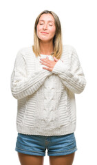 Poster - Young beautiful woman wearing winter sweater over isolated background smiling with hands on chest with closed eyes and grateful gesture on face. Health concept.