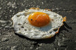 Sunny-side-up eggs fried on the hot asphalt. Heat wave and unbearable weather conditions in a city. Climate change concept.