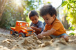 Two boys having fun playing together with toy truck in sand pit