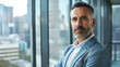© amila - Confident Successful Middle-Aged Caucasian Businessman Posing by Modern Office Window - Professional Portrait in Stylish Suit