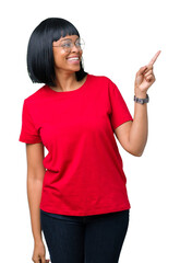 Sticker - Beautiful young african american woman wearing glasses over isolated background with a big smile on face, pointing with hand and finger to the side looking at the camera.