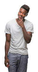 Sticker - Young african american man over isolated background with hand on chin thinking about question, pensive expression. Smiling with thoughtful face. Doubt concept.