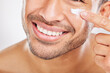 Happy man, hand or face cream closeup for beauty in studio with smile, natural cosmetics or glow for shine. Dermatology, antiaging or male model applying skincare lotion or creme on white background