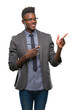 © Krakenimages.com - Young african american business man over isolated background smiling and looking at the camera pointing with two hands and fingers to the side.