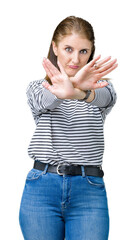 Canvas Print - Middle age mature beautiful woman wearing stripes winter sweater over isolated background Rejection expression crossing arms and palms doing negative sign, angry face