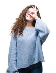 Wall Mural - Beautiful brunette curly hair young girl wearing sunglasses over isolated background doing ok gesture with hand smiling, eye looking through fingers with happy face.