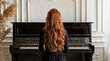 Back view of a woman with ginger red hair playing the piano in a modern living room