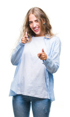 Sticker - Beautiful young blonde woman over isolated background pointing fingers to camera with happy and funny face. Good energy and vibes.