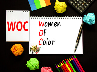 Wall Mural - WOC women of color symbol. Concept words WOC women of color on beautiful white note. Beautiful black background. Black calculator. Business WOC women of color social issues concept. Copy space.