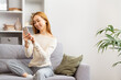 Happy Asian Woman Using Smartphone On Gray Sofa, Casual Lifestyle, Modern Living Room, Content Creator, Technology At Home