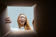 Excited Young Woman Opening A Large Cardboard Box At Home, Expressing Joy And Surprise, Ideal For Concepts Of Delivery, Unboxing, And Moving Day