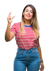 Wall Mural - Young beautiful woman casual look over isolated background smiling and confident gesturing with hand doing size sign with fingers while looking and the camera. Measure concept.