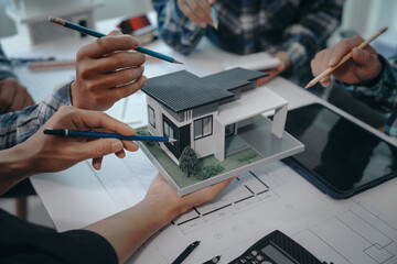 team of engineers in a meeting, drawing blueprints for condo, apartment, and house construction. neg