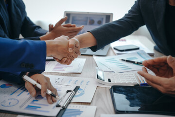 in a business team meeting, success is celebrated with a handshake. hands close up, dressed in forma