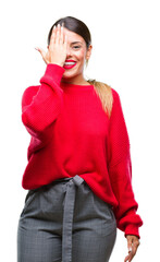 Poster - Young beautiful business woman wearing winter sweater over isolated background covering one eye with hand with confident smile on face and surprise emotion.