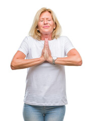 Sticker - Middle age blonde woman over isolated background begging and praying with hands together with hope expression on face very emotional and worried. Asking for forgiveness. Religion concept.