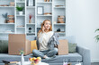 Young Woman Enjoying Phone Call While Unpacking In Modern Living Room, Surrounded By Boxes And Home Decor Amidst A Cozy Setup