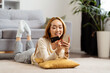 Young Woman Enjoying Online Shopping On Smartphone At Home, Smiling Asian Female Holding Credit Card, Lying Comfortably, Modern Living Room Setting.