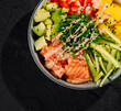 Fresh salmon poke bowl on dark slate background
