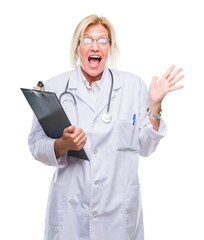 Canvas Print - Middle age blonde doctor woman holding clipboard over isolated background very happy and excited, winner expression celebrating victory screaming with big smile and raised hands