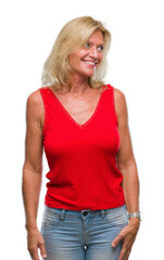 Poster - Middle age blonde woman over isolated background looking away to side with smile on face, natural expression. Laughing confident.