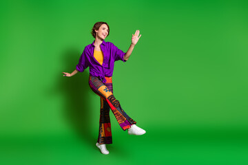 Sticker - Photo portrait of funny young woman in purple stylish shirt pants and brown bob haircut dancing joyful isolated on green color background