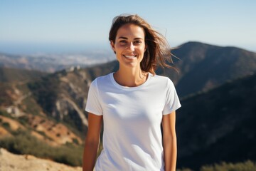 Wall Mural - Portrait of a happy woman in her 30s dressed in a casual t-shirt on panoramic mountain vista