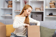 Young Woman Unpacking Box At Home, Expressing Excitement, Casual Lifestyle, Moving Day Concept, Indoor, Living Room