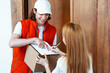 Friendly Courier Delivering Package At Home, Woman Signing Receipt On Clipboard, Customer Service, Home Delivery, Satisfaction