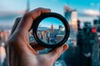 © Bambalino Studio - A hand holding a camera lens that is looking at a city. The city is New York and the lens is a viewfinder