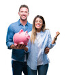 © Krakenimages.com - Young couple in love holding piggy bank over isolated background screaming proud and celebrating victory and success very excited, cheering emotion