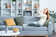 Young Woman Taking Selfie On Smartphone In Cozy Living Room, Casual Lifestyle, Indoor Relaxation, Modern Home Interior