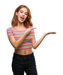 Wall Mural - Young beautiful woman over isolated background amazed and smiling to the camera while presenting with hand and pointing with finger.