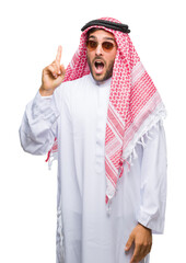 Wall Mural - Young handsome man wearing keffiyeh over isolated background pointing finger up with successful idea. Exited and happy. Number one.
