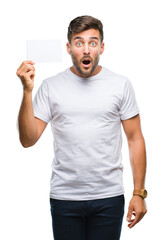 Wall Mural - Young handsome man holding blank card over isolated background scared in shock with a surprise face, afraid and excited with fear expression