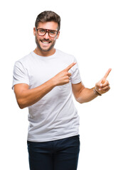 Canvas Print - Young handsome man wearing glasses over isolated background smiling and looking at the camera pointing with two hands and fingers to the side.