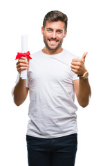 Canvas Print - Young handsome man holding degree over isolated background happy with big smile doing ok sign, thumb up with fingers, excellent sign