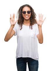 Wall Mural - Young hispanic woman wearing sunglasses showing and pointing up with fingers number nine while smiling confident and happy.