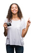 © Krakenimages.com - Young hispanic woman taking pictures using vintage camera very happy pointing with hand and finger to the side