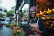 © shelbys - African American woman holding a tablet computer at an outdoor cafe Fictional Character Created By Generative AI.