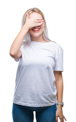 Sticker - Young blonde woman over isolated background smiling and laughing with hand on face covering eyes for surprise. Blind concept.