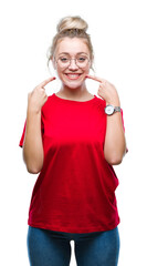 Sticker - Young blonde woman wearing glasses over isolated background smiling confident showing and pointing with fingers teeth and mouth. Health concept.